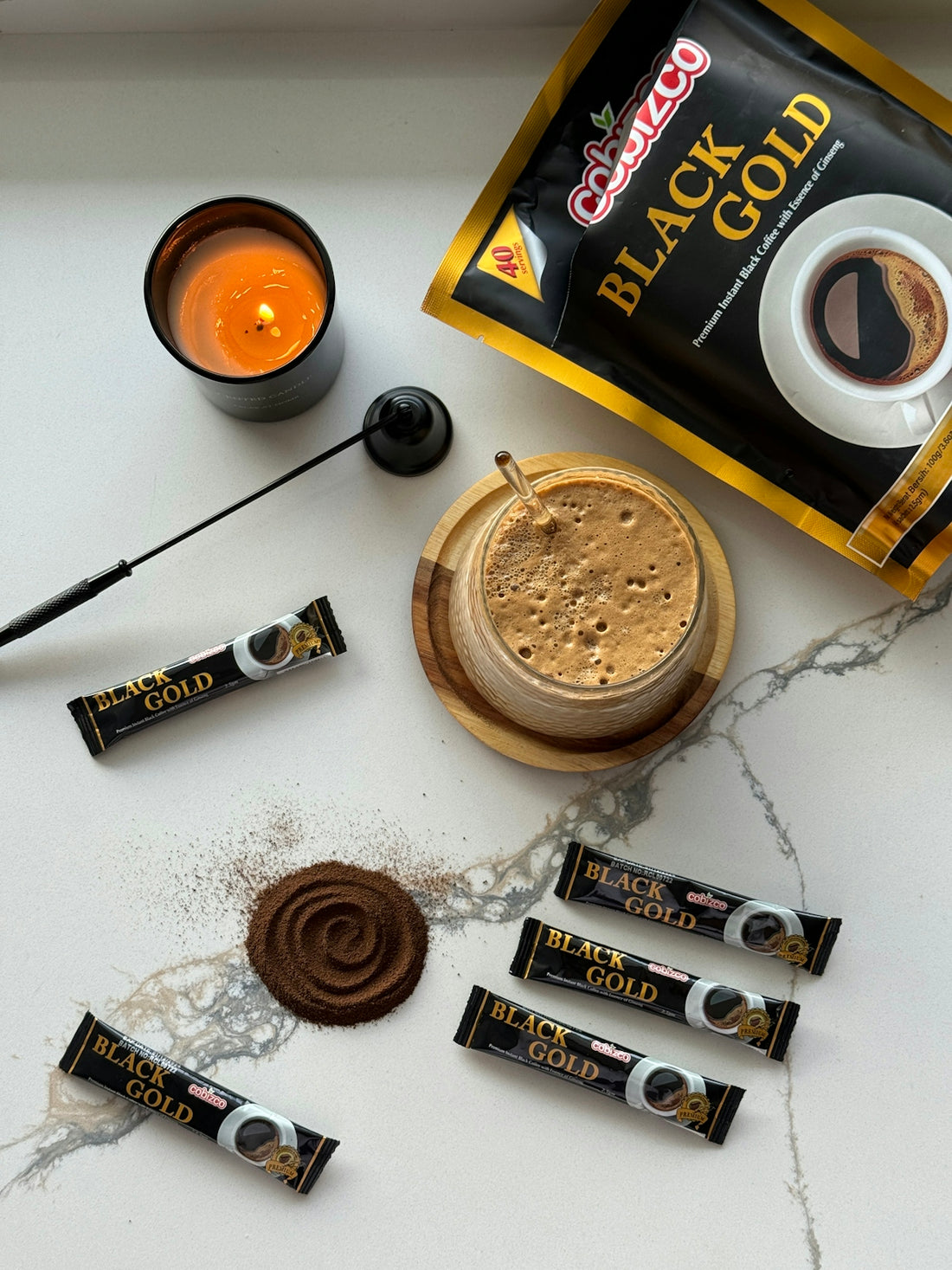 a table topped with a cup of coffee next to a bag of black gold