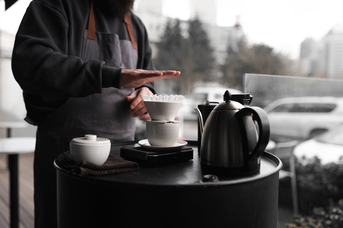A man standing next to a table with a cup of coffee on it
