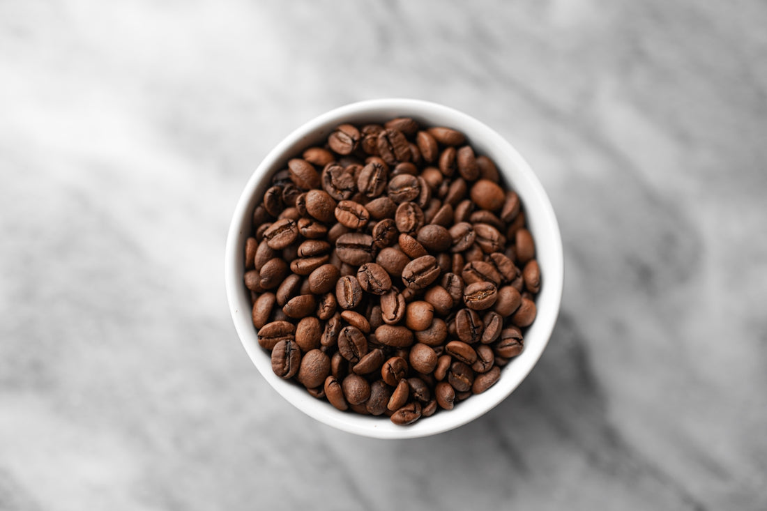 A small white bowl filled with coffee beans