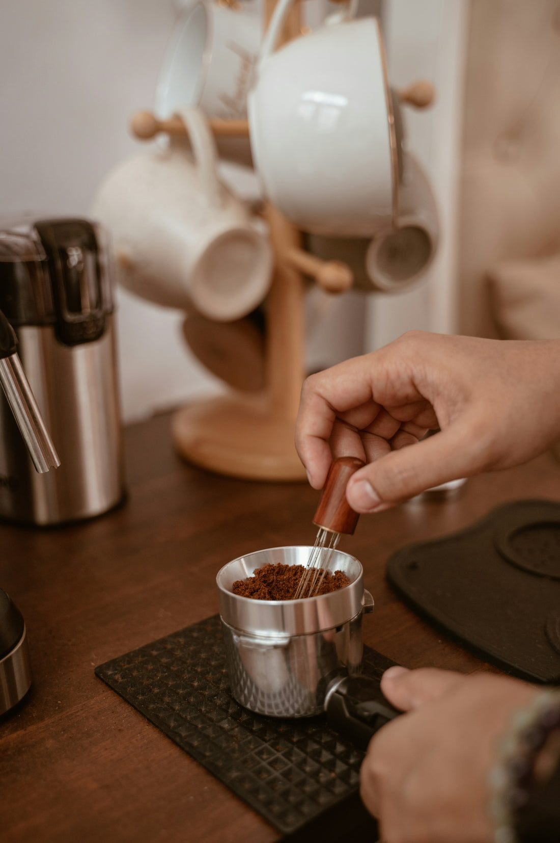 A person stirring a cup of coffee on a table