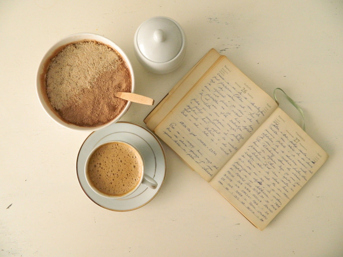 white ceramic mug beside book