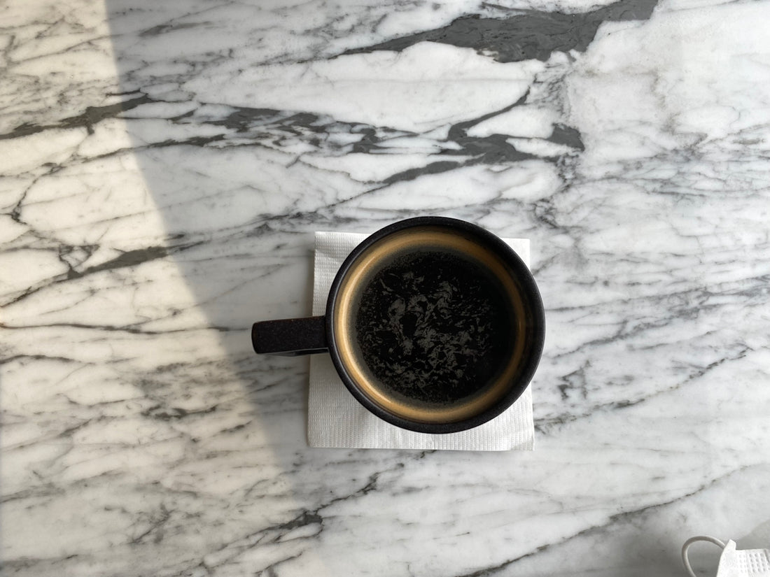 a cup of coffee sitting on top of a napkin