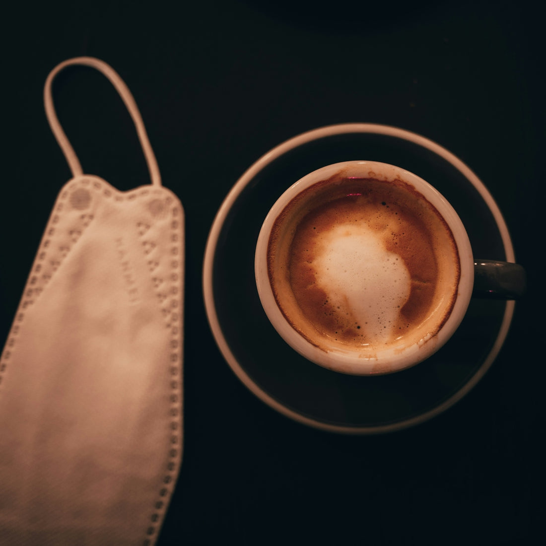 a cup of coffee on a saucer next to a napkin