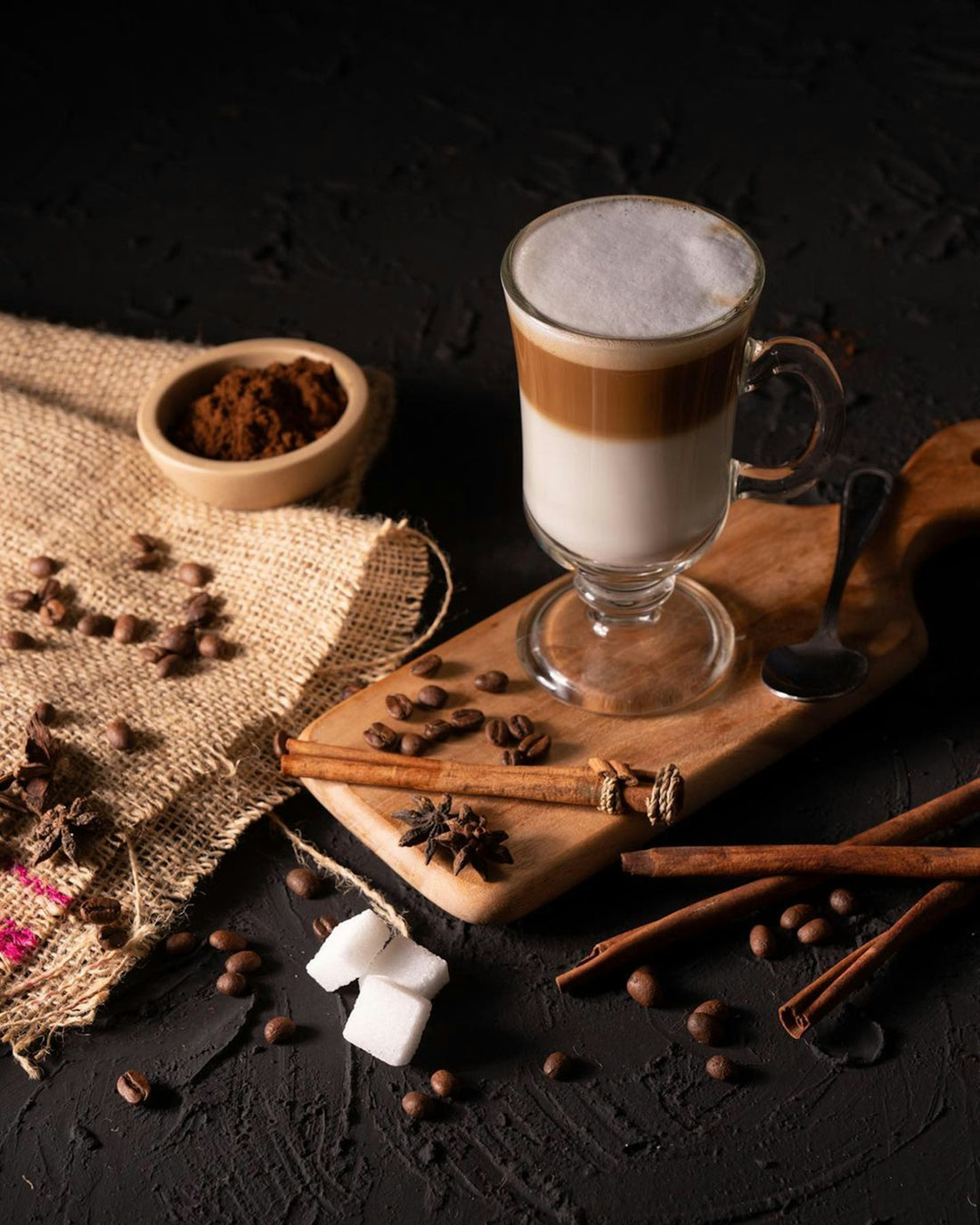 a cup of coffee and cinnamons on a table