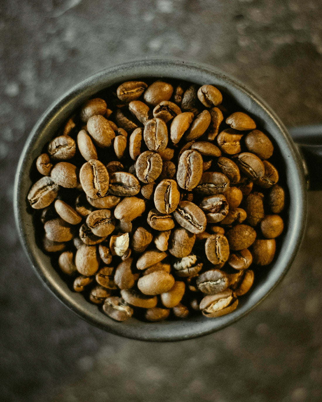 a cup filled with coffee beans on top of a table