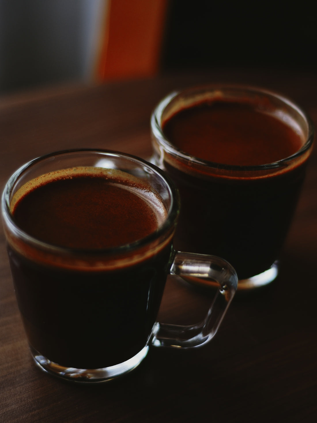 Two glasses of rich, dark espresso.
